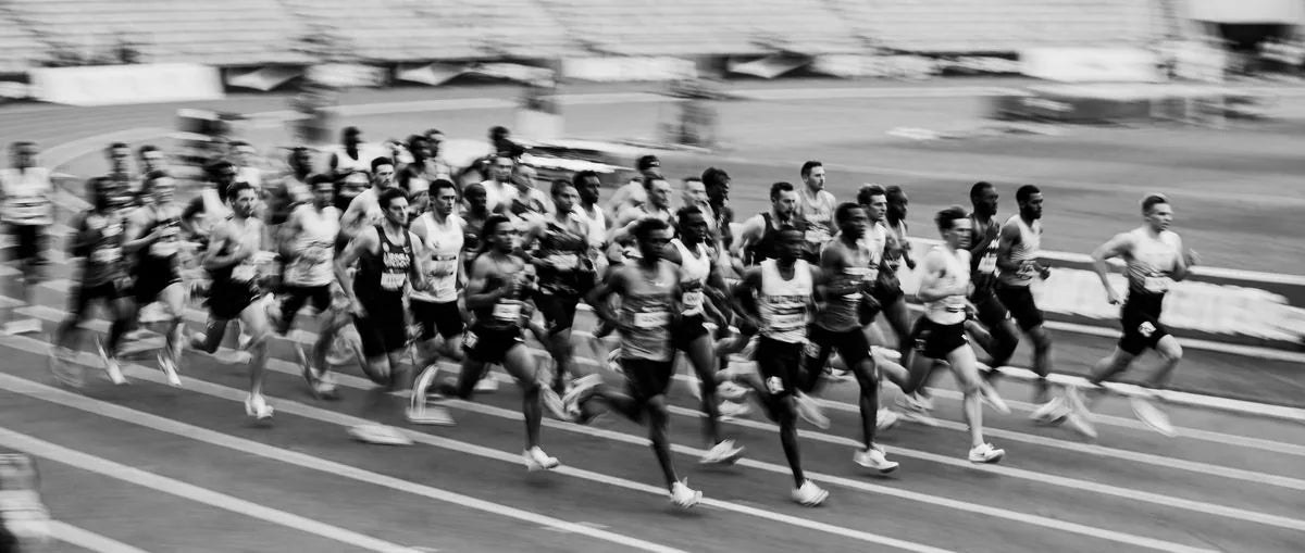 Runners racing on a track, black and white