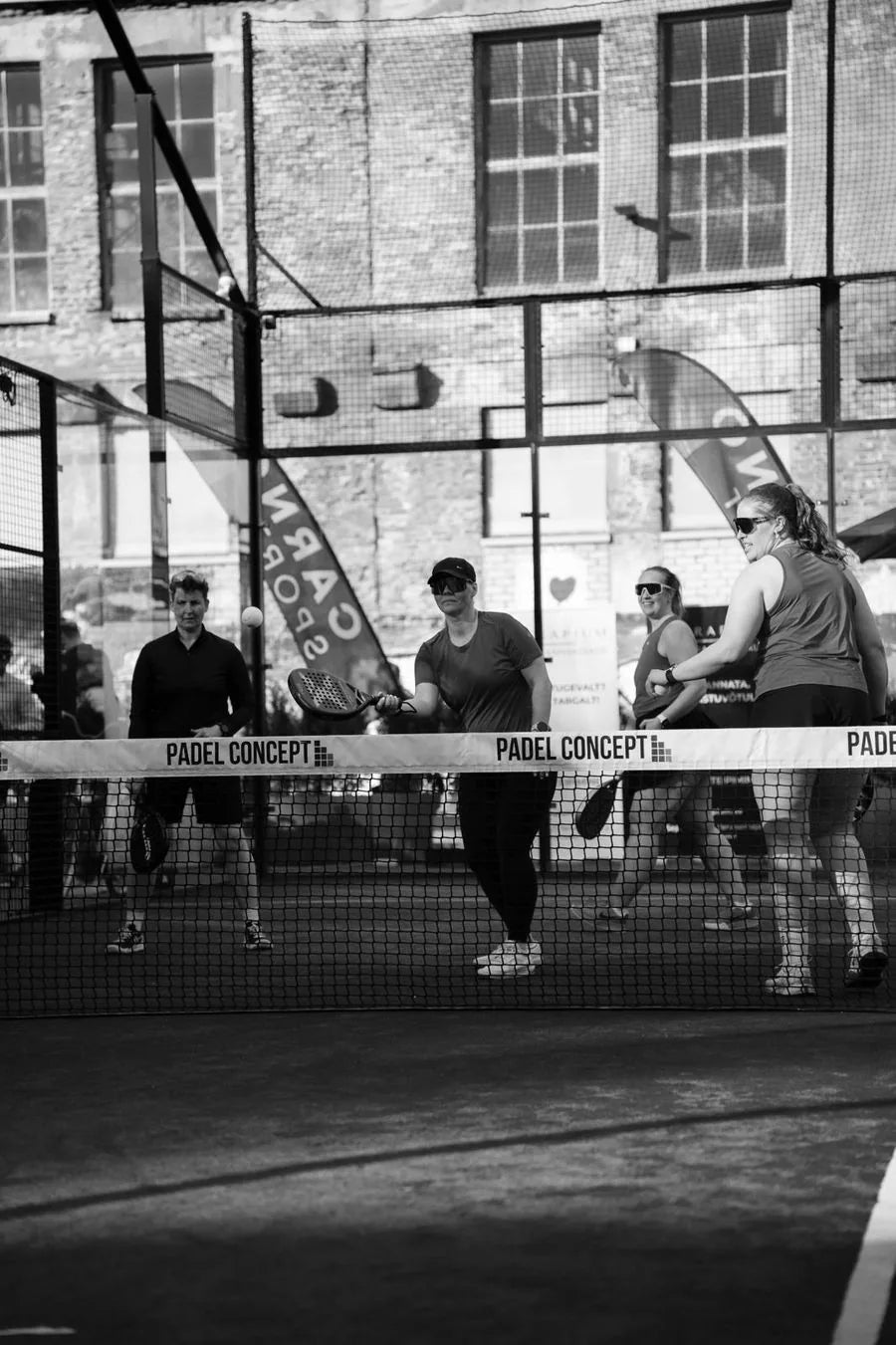 Padel match with the Carnosport flag behind the court