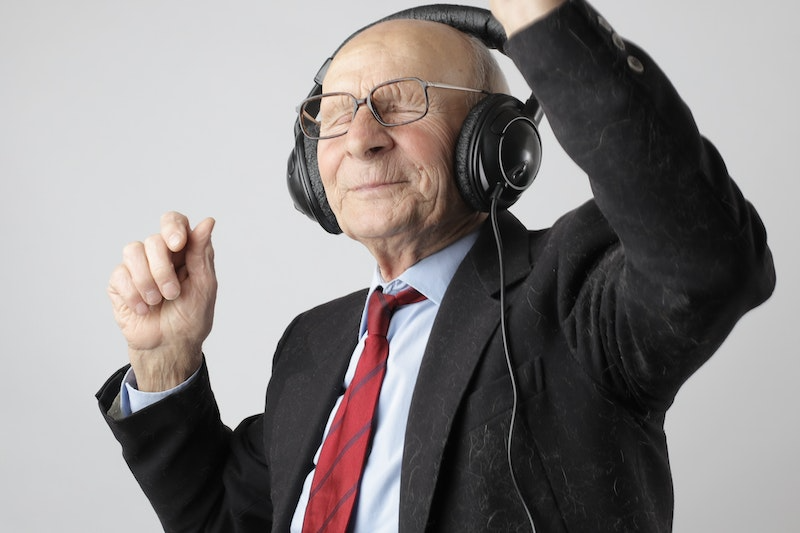 Old man listening with his headphones on